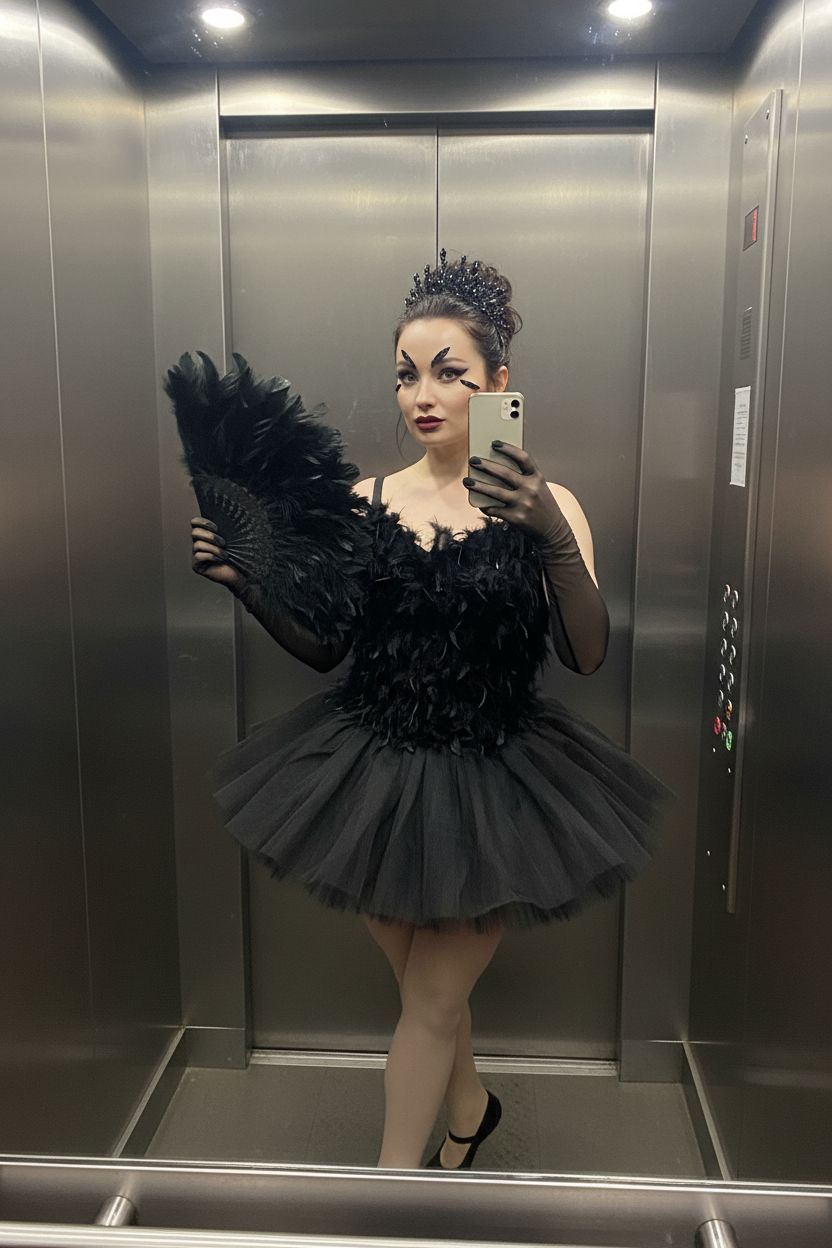 Фото женщины в образе, вдохновлённом «Чёрным лебедем»: чёрный топ с перьями, короткая пачка, балетки, волосы собраны в небрежный пучок с чёрной тиарой. На руках — полупрозрачные чёрные перчатки, в руке веер из перьев. Макияж — чёрные стрелки, матовые тёмные губы, перья на бровях. Она делает фото в зеркале лифта на iPhone. Реалистичный повседневный снимок.
