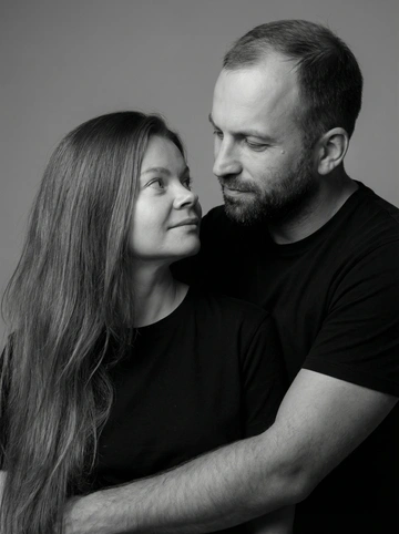   Сделай двоим семейную фотосессию. Любящий муж с любящей женой. Фото портретное в студии в черно белом стиле. Муж и жена одеты в рубашки подходящие по стилю и цвету друг другу. Мягкий свет который подчеркивает их любовь