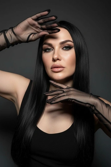 На моей фотографии крупным планом изображена гламурная женщина на темно-сером фоне, в прозрачных чёрных перчатках и чёрном платье. Она позирует, обрамляя лицо руками, отбрасывая на глаза эффектные тени. Яркий макияж глаз с аккуратной подводкой, гладкая и безупречная кожа, кинематографическое освещение, стиль высокой моды, атмосфера таинственности и соблазнительности. 