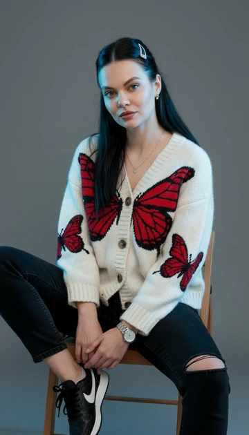 Save my facial features. Close-up portrait edited in HD, woman with porcelain skin, long hair pulled back halfway with a clip, white knit wool blue cardigan with voluminous embroidered red butterflies, black jeans with a hole at the knee, a watch and necklace, black Nike sneakers, light makeup with brown eyeshadow and glossy nude brown lipstick, natural eyeliner, gray studio background with blue light highlighting her face. Example: sitting on a chair, deliberately holding her hands.