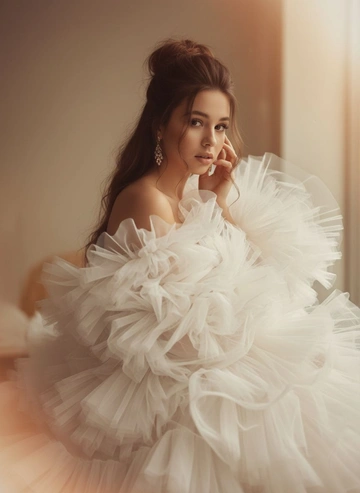 Промпт пользователя:
Создай изображение меня
Максимально сохрани мою внешность
Редакционный портрет красивой женщины из журнала высокой моды, она тонула в объемном пышном белом платье из полупрозрачной органзы и тюля — много слоев, оборок и летящих складок, ткань обволакивает тело и лицо по краям; бархатистая загорелая кожа, естественный нюдовый макияж, небрежный высокий пучок с распущенными локонами, цвет волос как на фото, элегантные серьги-люстры. Размытый, мечтательный пленочный фильтр: мягкое рассеивание, размытие по краям, кинематографический блум, теплые янтарные и кремовые тона, легкая дымка в воздухе. Поза: крупный план на 3/4, корпус слегка наклонен вперед, кисть на лице, пристальный взгляд в камеру. Освещение: мягкий рассеянный естественный свет из окна, теплый ободочный свет